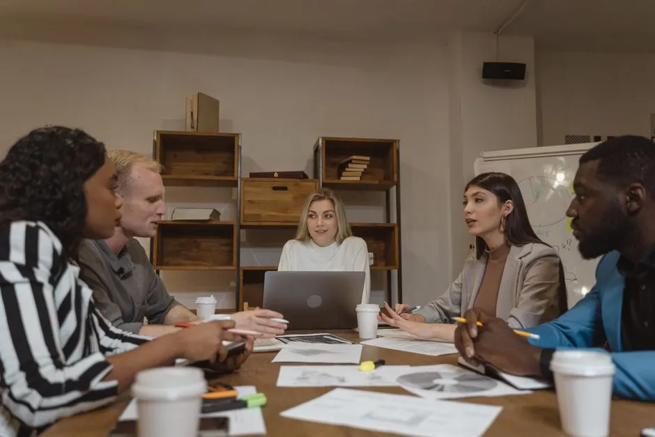 Group of professionals collaborating in a modern office setting during a strategic meeting.