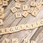 Regulatory compliance concept with wooden tiles spelling 'Regulation' for USA crypto license and digital assets law