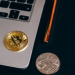 Close-up of Bitcoin and cryptocurrency coins on a laptop, representing Brazil's new crypto license law and Central Bank fintech regulation
